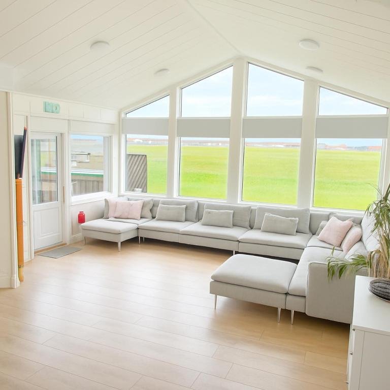Bright living room with large windows at Hafnir Guesthouse
